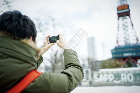 观光旅游拿着手机拍照的男性图片