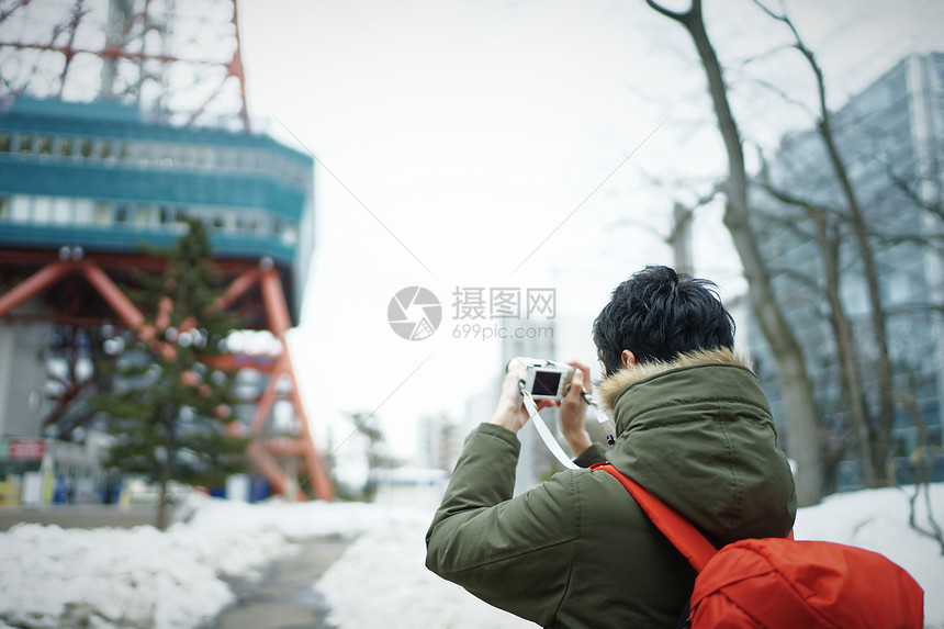 旅游拿着相机拍照记录的男青年图片