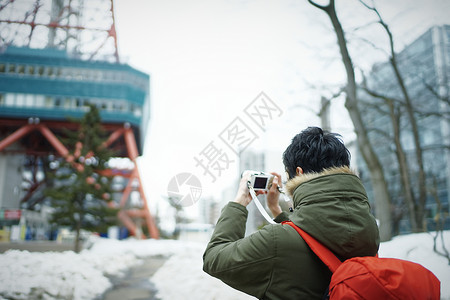 旅游拿着相机拍照记录的男青年图片