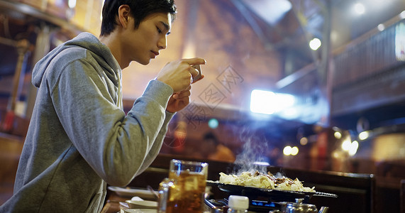 拿着手机拍食物照片的男青年图片