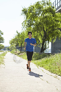 公园里慢跑锻炼的男青年图片