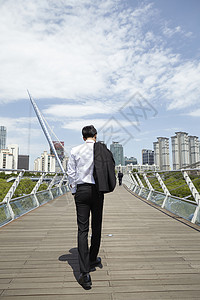 拿着西装外套的成年男子背影背景图片