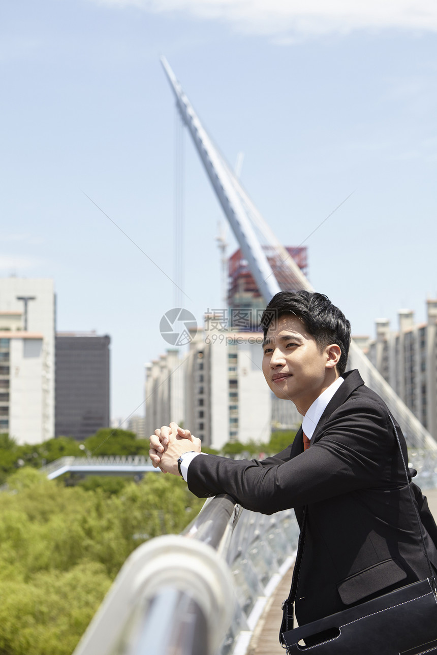 靠在栏杆上的商务男性图片