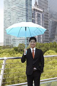 穿着西装遮着伞的成年男性图片