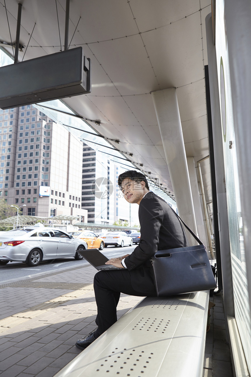 坐在车站等车的商务人士图片