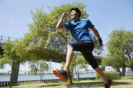 公园里跑步运动的男青年图片