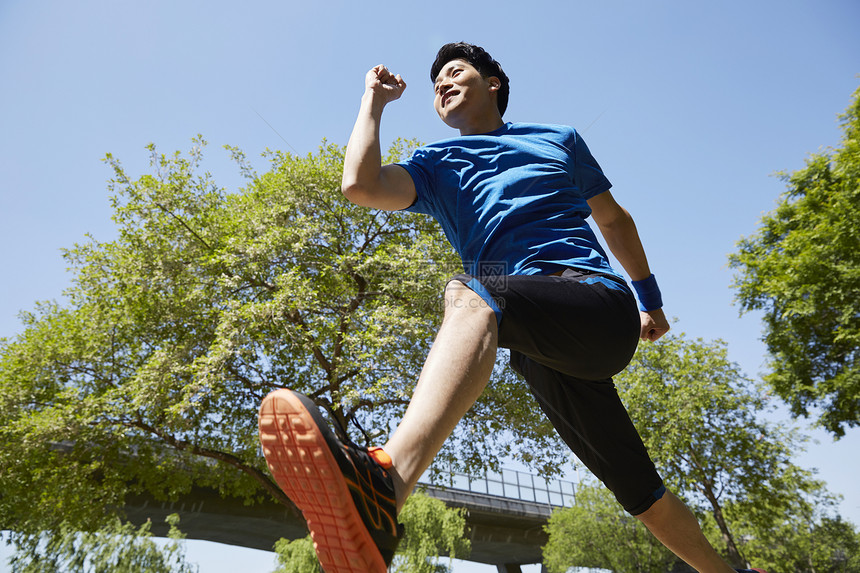 公园里跑步运动的男青年图片