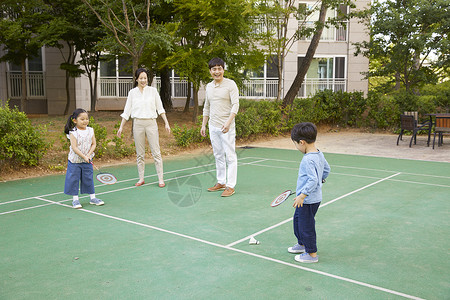 女子羽毛球父母陪着小朋友打羽毛球背景