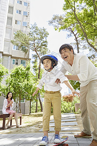 爸爸陪着小男孩玩滑板图片