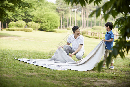 爸爸和儿子整理野餐垫图片