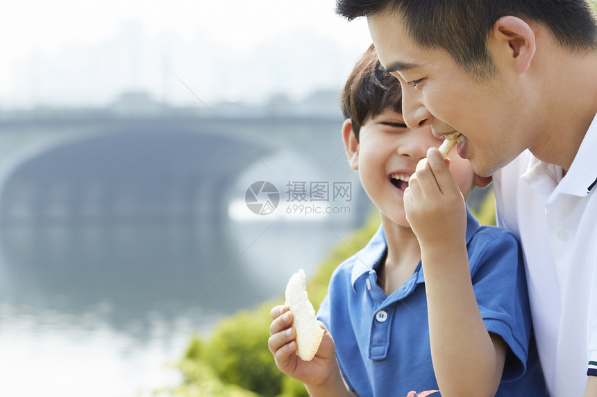  给爸爸吃食物的小男孩图片