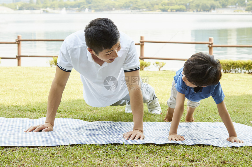 父子二人在露营垫上锻炼身体图片