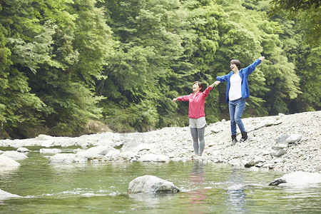 两个女人在河边放松享受自然图片
