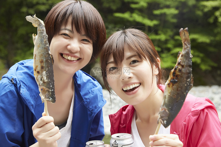 两个女人在河岸边放松享受烤鱼图片
