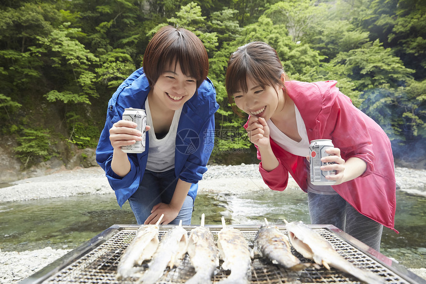 两个女人在河岸边放松享受户外烧烤图片