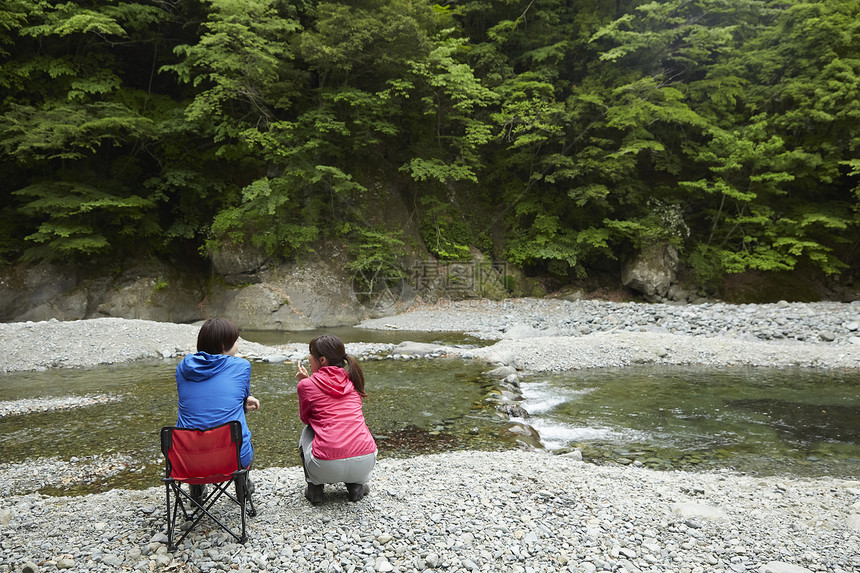 两个女人在河岸边放松享受自然图片