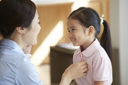 妈妈帮女孩整理衣服图片