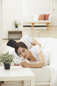 妇女在床上看手机图片