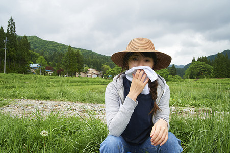 在田地里玩蒲公英的女性图片