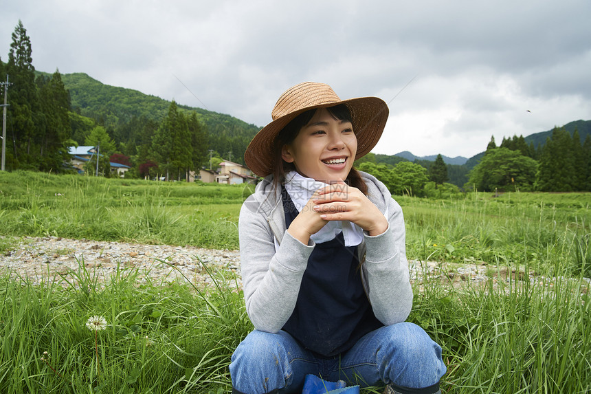 种植水稻后在田里休息的年轻农民图片