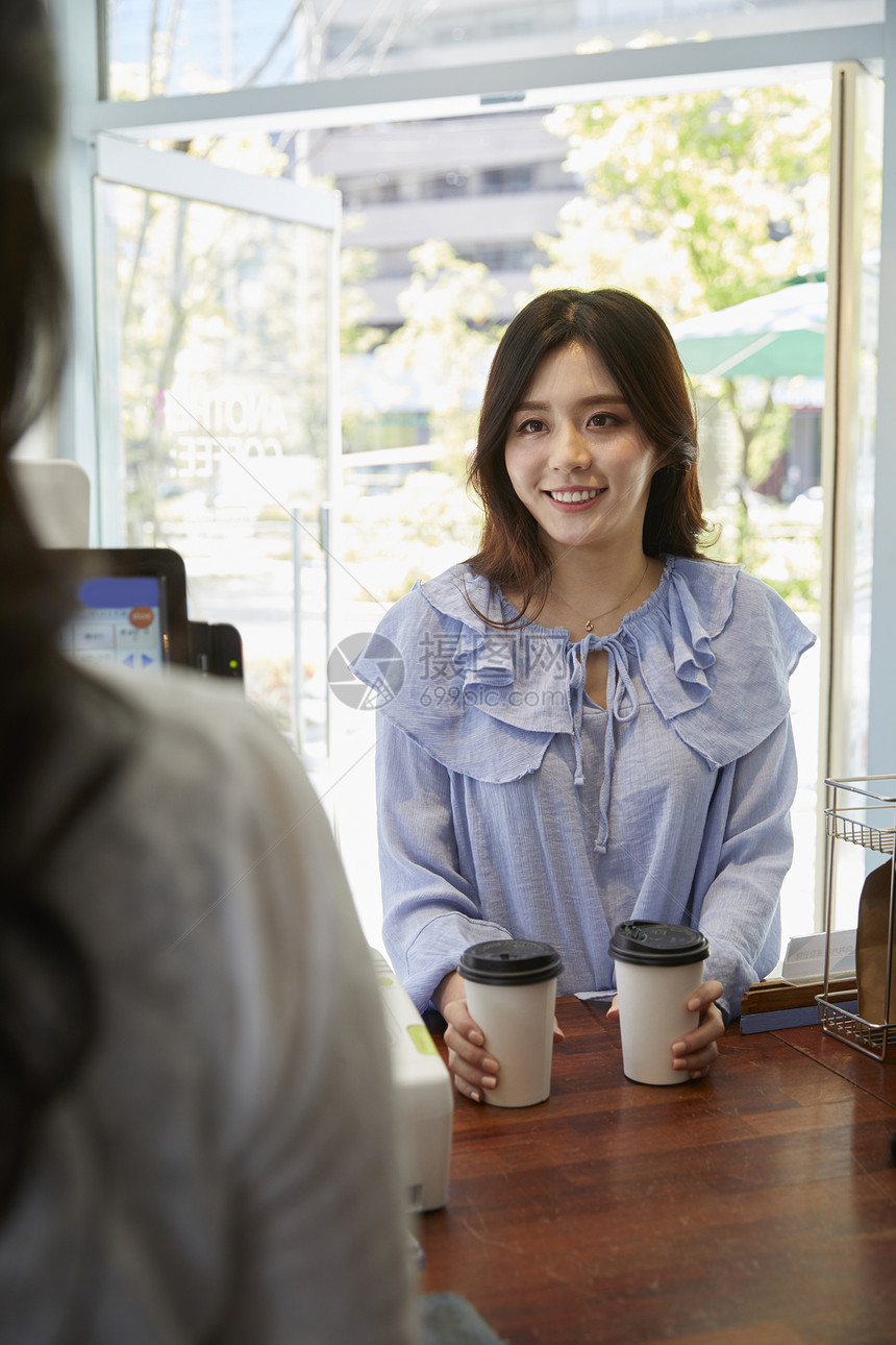 年轻女子在咖啡店买咖啡图片