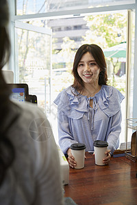 年轻女子在咖啡店买咖啡图片