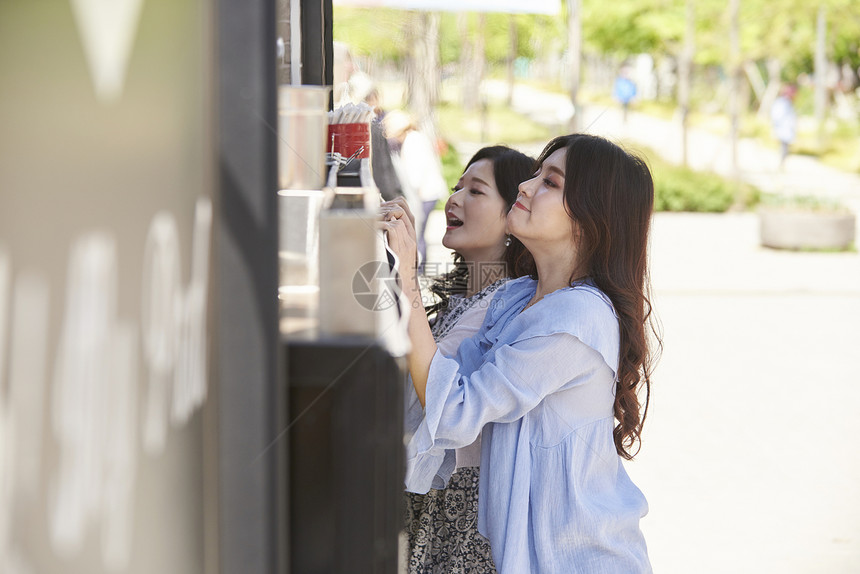 年轻女子看着食品车点单图片