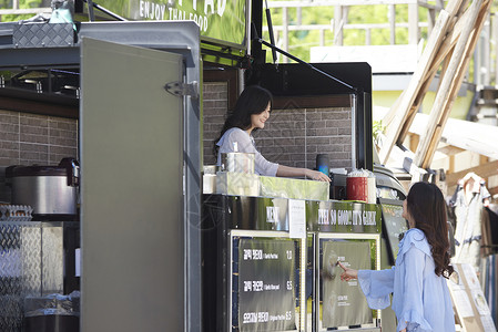 年轻女子在食品车旁点餐图片