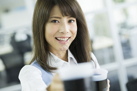 拿着茶杯微笑的职业女性图片