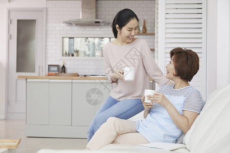 女儿陪妈妈在沙发上喝咖啡图片