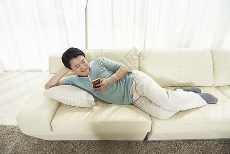 男子在沙发上看手机成年男子高清图片素材