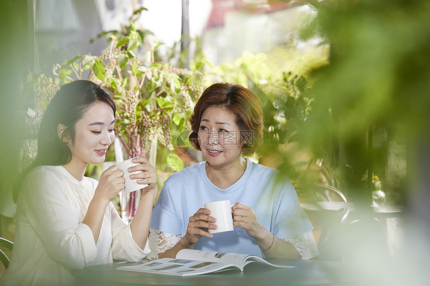 户外女儿开心的跟母亲喝咖啡聊家常图片