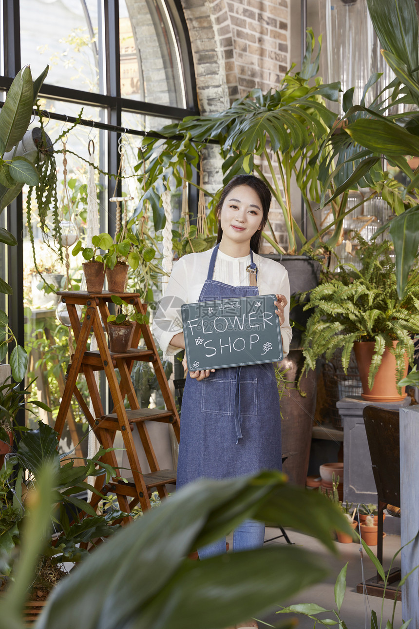 幸福少女拿着花店招聘站在店里图片