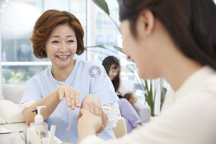 母女在美容化妆品店做美甲图片