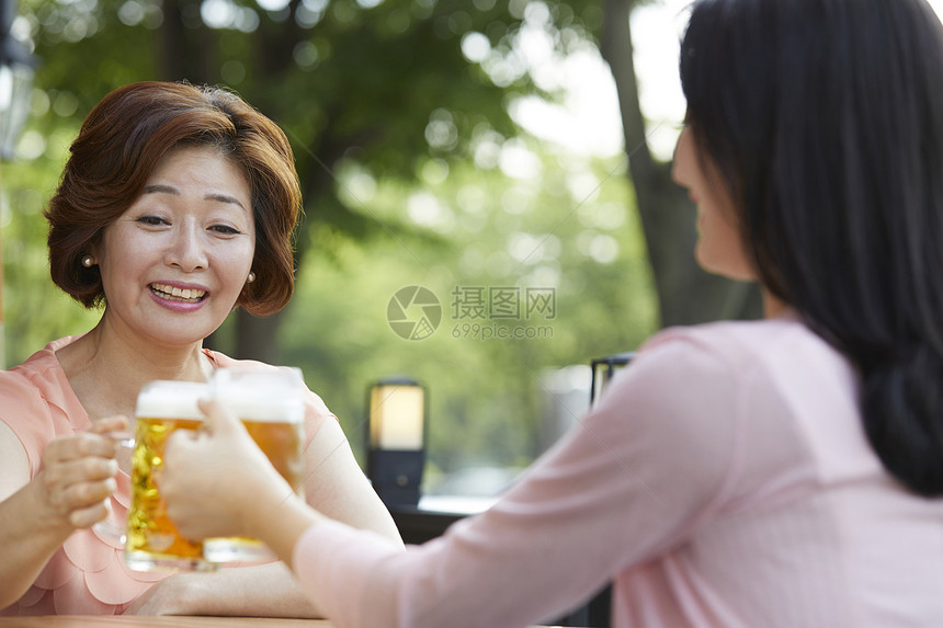 母亲和女儿一起户外喝啤酒图片