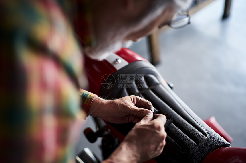 在修理摩托车的老人图片