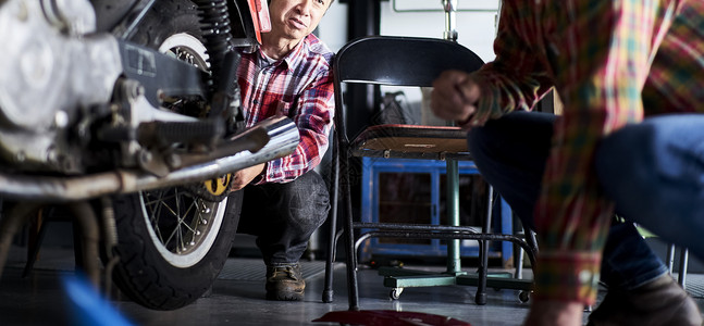 在车库修理摩托车的老人图片