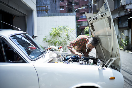 修理复古汽车的老人图片