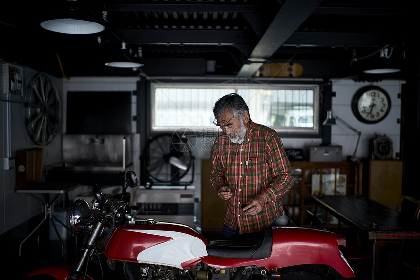 修理摩托车的老人图片