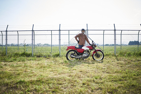 草地上骑摩托车的人高清图片