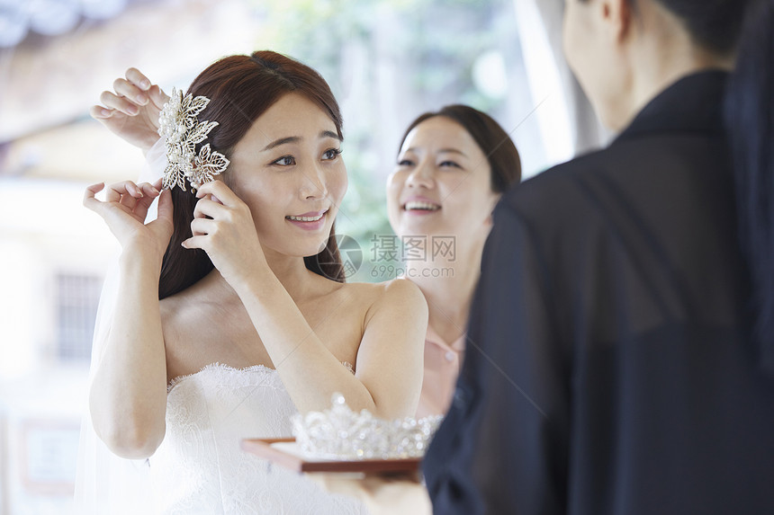 在婚纱店试穿婚纱戴头饰的新娘图片