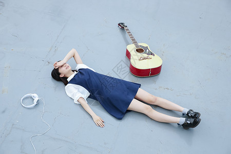 躺地上哭躺在地上的女孩和她的吉他背景