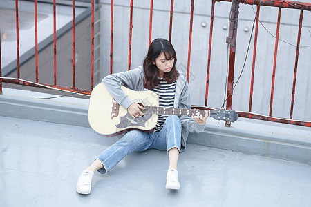在天台上弹吉他放松的学生图片