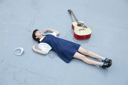 躺在天台地板上放松休息的女孩图片