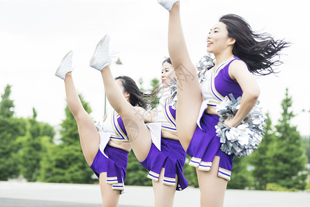 女孩啦啦队员年轻漂亮的啦啦队员在跳舞背景