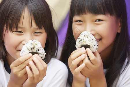 拿着饭团微笑的小女孩们图片