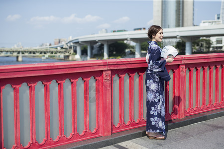 户外穿着日式和服拿着扇子的年轻女性图片