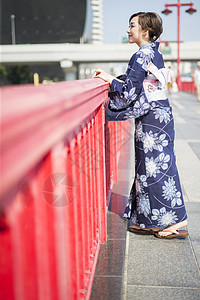 穿着日式服装靠在栏杆上的年轻女性图片
