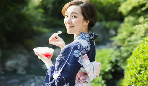 穿着日式服装吃冰微笑的年轻女性图片