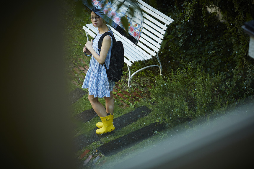 在雨中散步的年轻忧郁女性图片